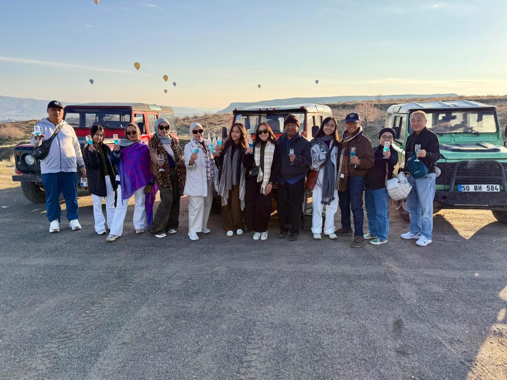 Rombongan jamaah Safari Suci menikmati tur jeep eksklusif dengan latar balon udara di Cappadocia, Turki. Jika Anda mencari referensi paket umroh apa saja yang mencakup wisata premium, Umroh Plus Turki adalah jawabannya.
